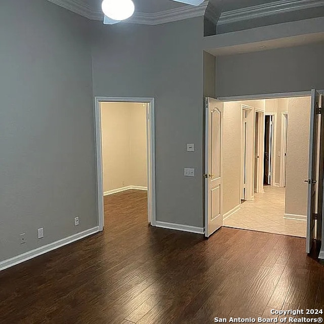 spare room featuring crown molding and dark hardwood / wood-style flooring