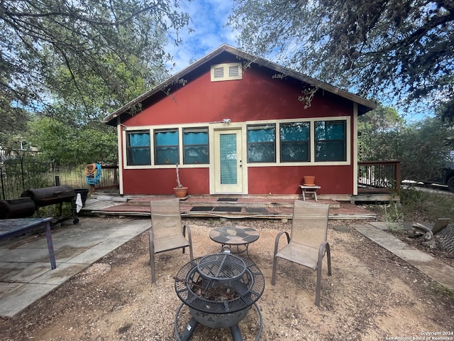 back of house with a fire pit and a patio area