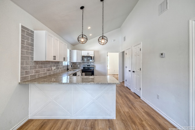 kitchen with pendant lighting, kitchen peninsula, backsplash, white cabinetry, and appliances with stainless steel finishes