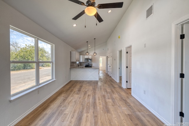 unfurnished living room with light wood-type flooring, ceiling fan, and high vaulted ceiling