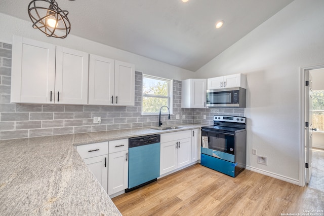 kitchen featuring appliances with stainless steel finishes, white cabinetry, lofted ceiling, decorative light fixtures, and sink