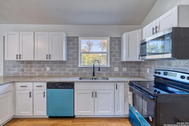 kitchen with appliances with stainless steel finishes, light hardwood / wood-style floors, white cabinetry, and sink