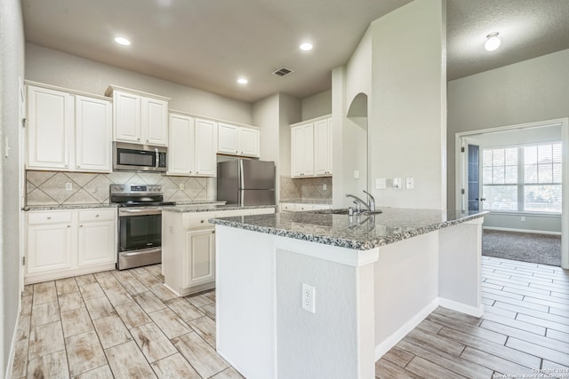 kitchen featuring white cabinets, appliances with stainless steel finishes, and sink