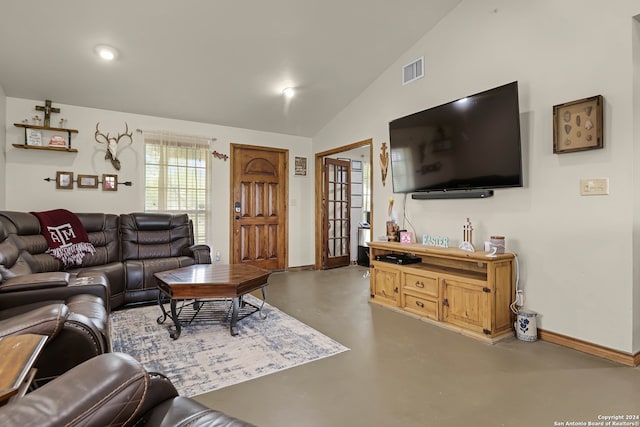 living room with lofted ceiling and concrete floors