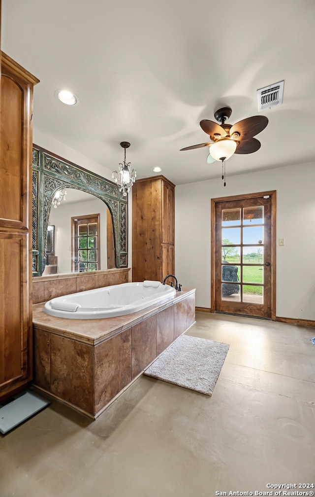 bathroom featuring a relaxing tiled tub, ceiling fan with notable chandelier, and concrete floors