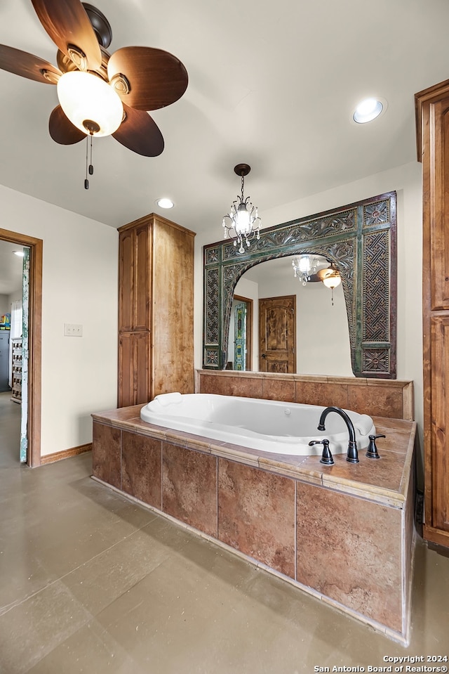 bathroom with ceiling fan with notable chandelier, concrete floors, and tiled tub