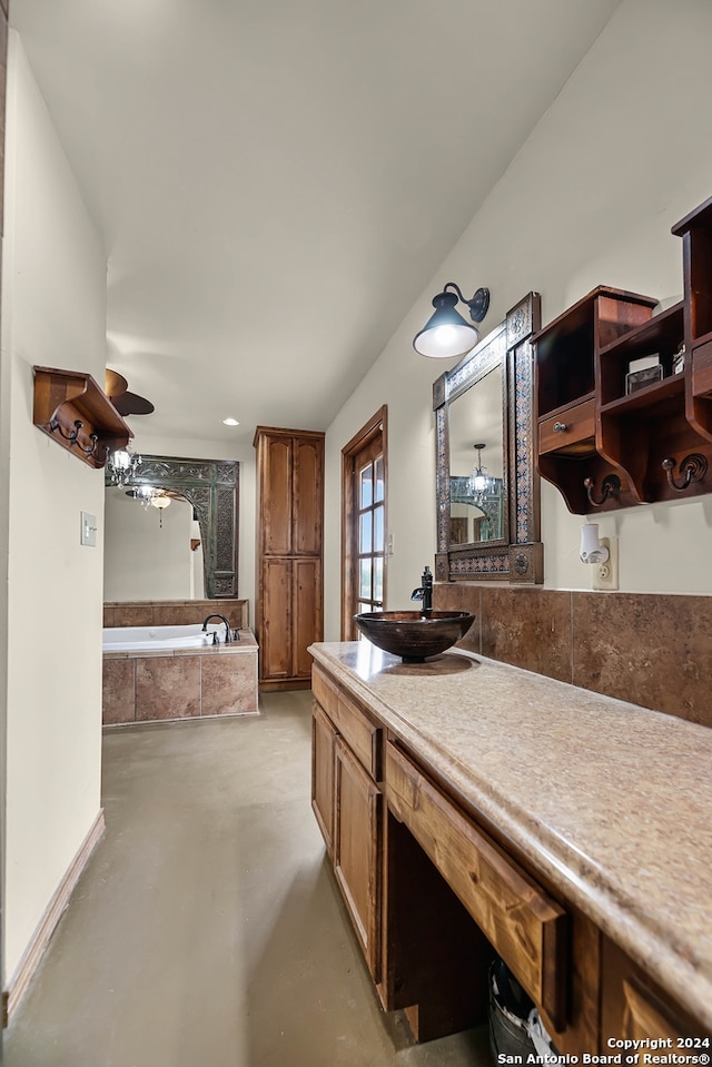 bathroom with vanity, concrete floors, tiled tub, and ceiling fan