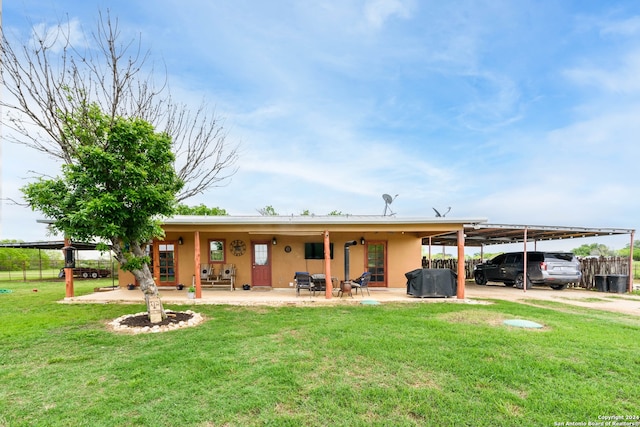 rear view of property featuring a patio and a lawn