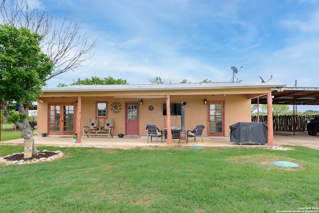 rear view of property with a patio area and a lawn