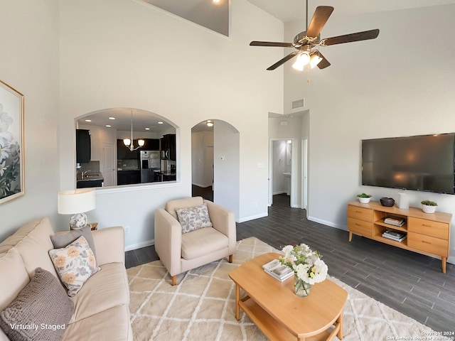 living room with wood-type flooring, a towering ceiling, and ceiling fan