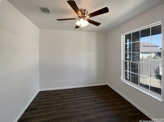 empty room with dark hardwood / wood-style floors and ceiling fan