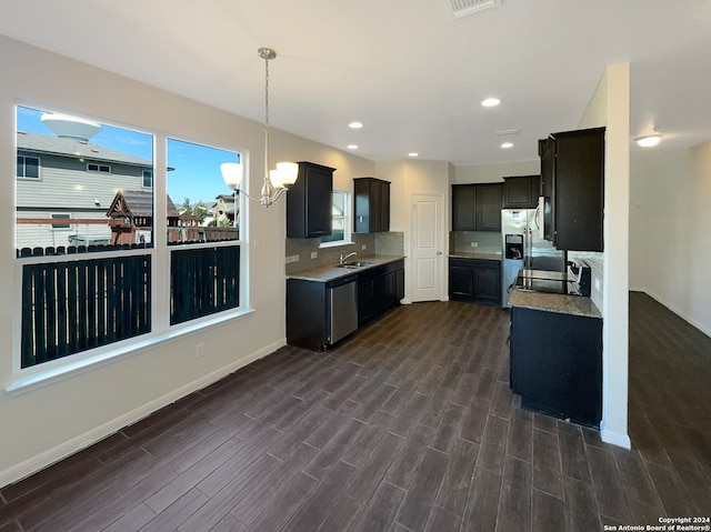 kitchen featuring a chandelier, dark hardwood / wood-style floors, sink, backsplash, and appliances with stainless steel finishes