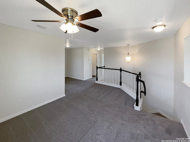 unfurnished room featuring dark colored carpet and ceiling fan