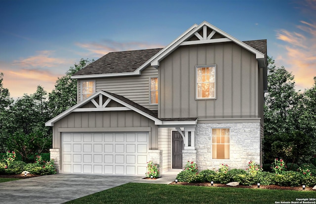 view of front of home featuring concrete driveway, stone siding, board and batten siding, and a shingled roof