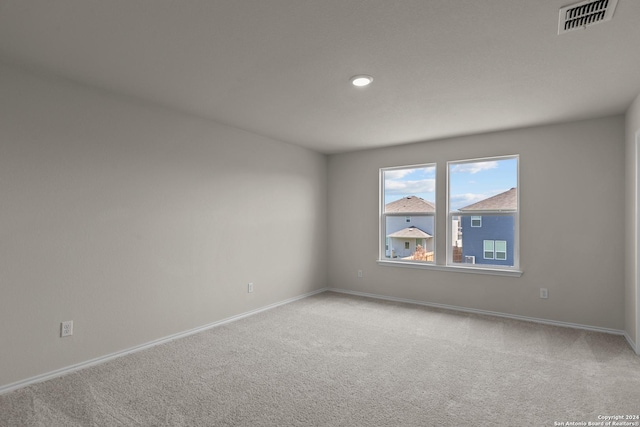 carpeted spare room with baseboards, visible vents, and recessed lighting