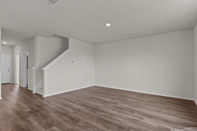unfurnished living room featuring recessed lighting, baseboards, stairs, and dark wood-style floors