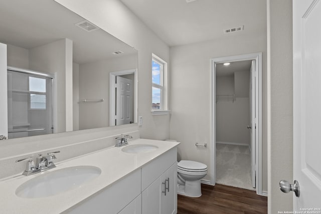 bathroom with wood finished floors, a sink, and visible vents