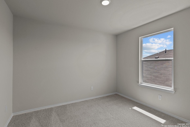spare room with baseboards and carpet floors