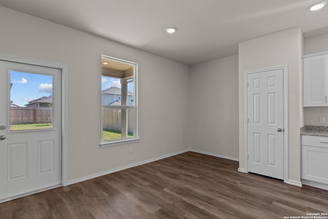 unfurnished dining area featuring dark hardwood / wood-style flooring