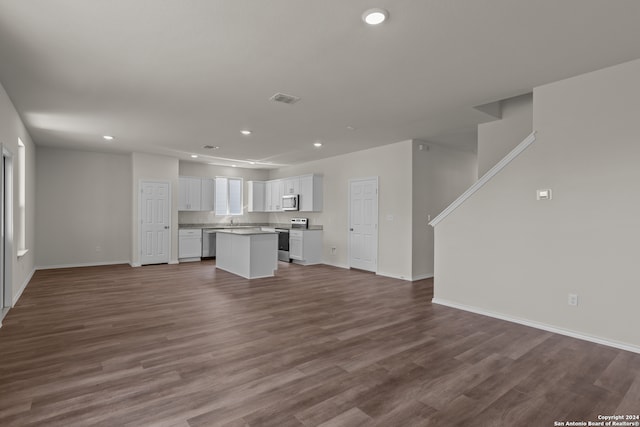 unfurnished living room featuring hardwood / wood-style flooring and sink