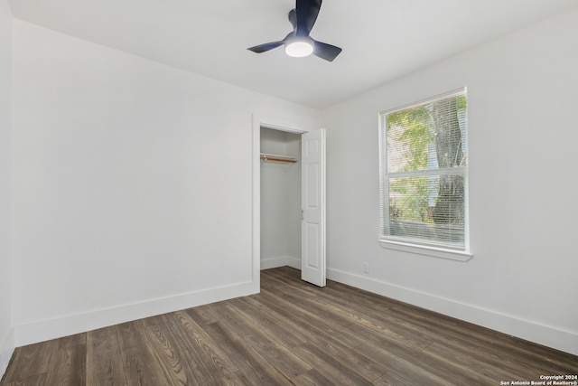 unfurnished bedroom with dark hardwood / wood-style floors, ceiling fan, and a closet