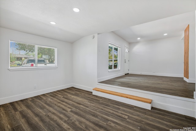 empty room with lofted ceiling and dark wood-type flooring