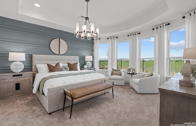 bedroom featuring a tray ceiling, multiple windows, and light colored carpet