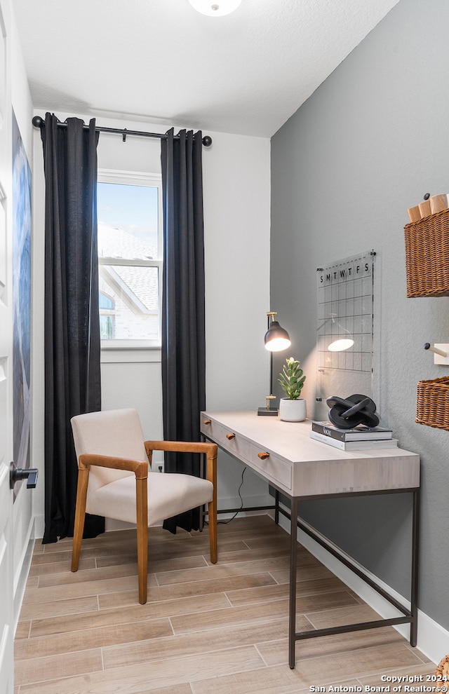 home office with light hardwood / wood-style flooring