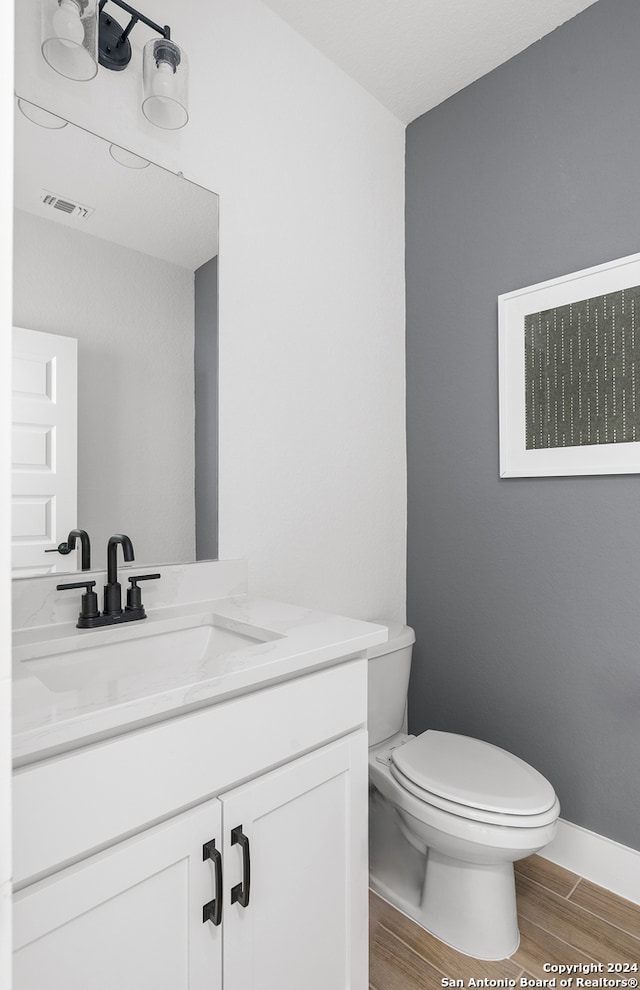 bathroom featuring hardwood / wood-style floors, vanity, and toilet