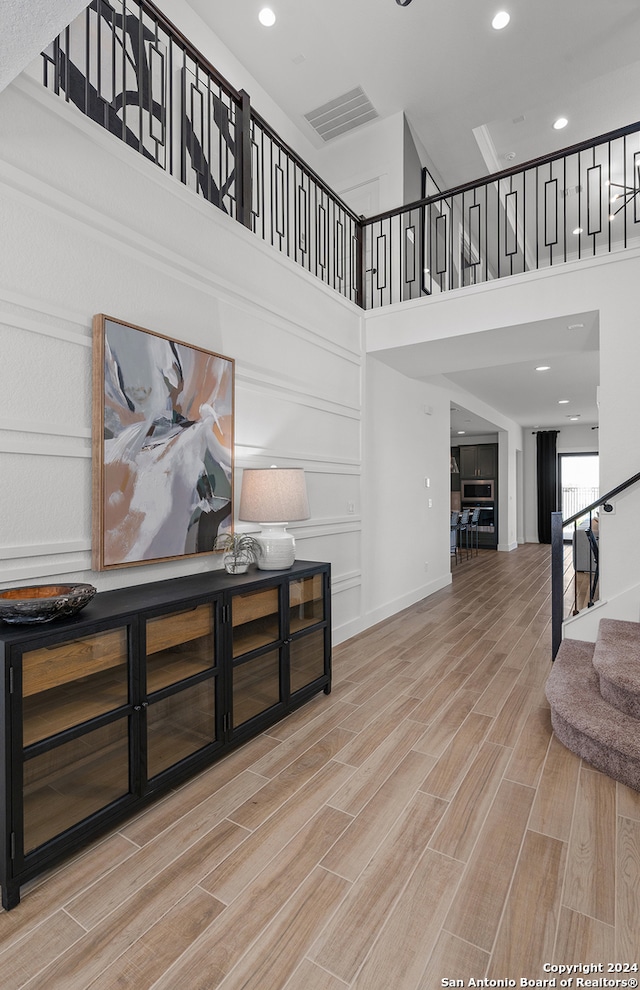 living room featuring a high ceiling and light hardwood / wood-style flooring