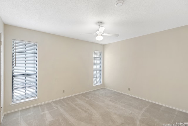 carpeted empty room featuring a textured ceiling and ceiling fan