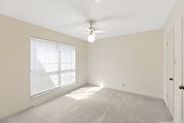 unfurnished room featuring a textured ceiling and light colored carpet