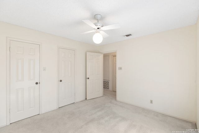 unfurnished bedroom with ceiling fan and light colored carpet