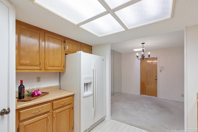 kitchen featuring hanging light fixtures, white fridge with ice dispenser, an inviting chandelier, and light colored carpet