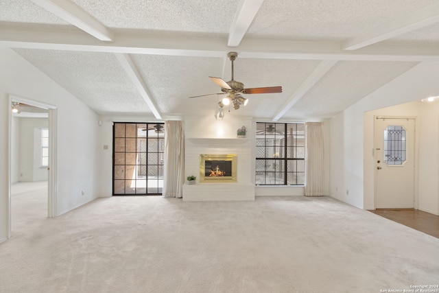 unfurnished living room with light carpet, a brick fireplace, and a textured ceiling