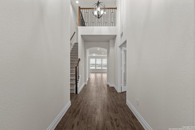 corridor featuring an inviting chandelier and dark hardwood / wood-style flooring