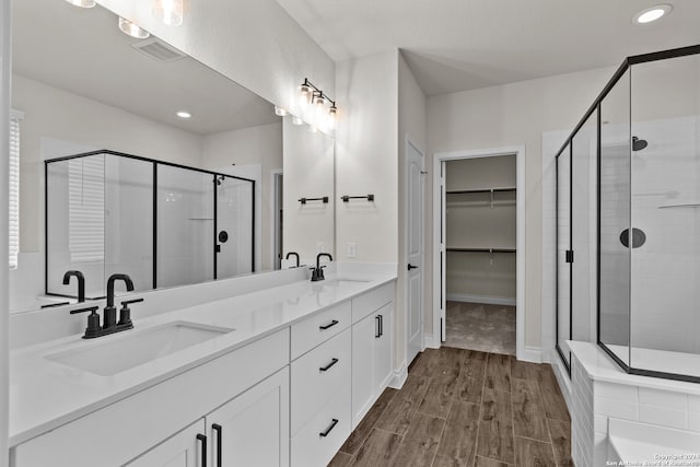 bathroom with walk in shower, vanity, and hardwood / wood-style floors