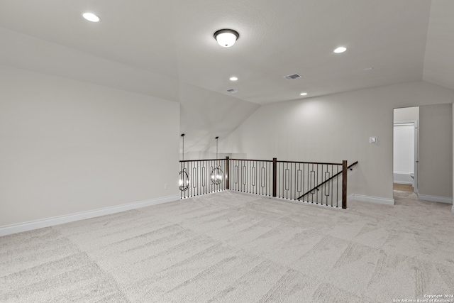 unfurnished room with lofted ceiling and light colored carpet