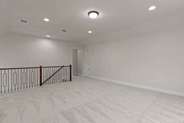 carpeted empty room featuring lofted ceiling