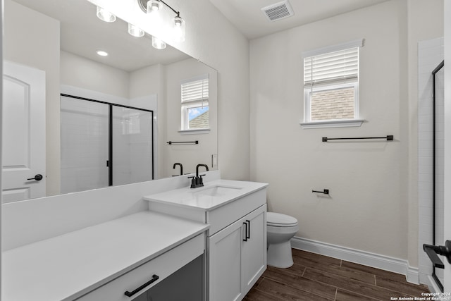 bathroom with walk in shower, vanity, toilet, and hardwood / wood-style flooring