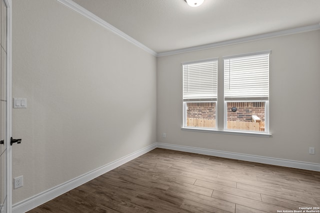 spare room featuring hardwood / wood-style flooring and ornamental molding