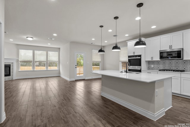 kitchen featuring pendant lighting, a wealth of natural light, a center island with sink, and appliances with stainless steel finishes