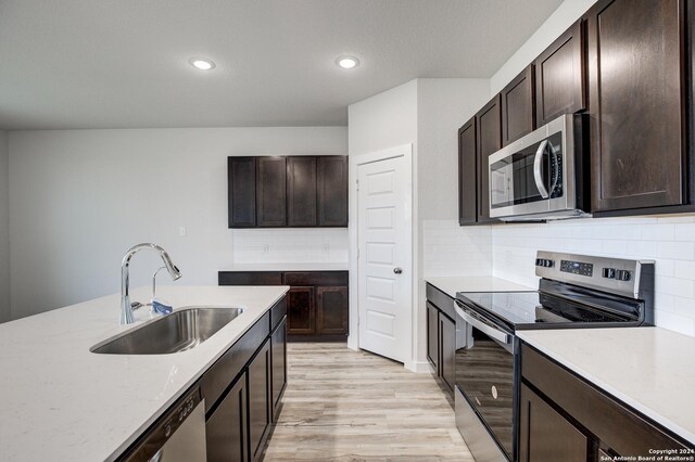 kitchen featuring light hardwood / wood-style floors, sink, appliances with stainless steel finishes, and tasteful backsplash