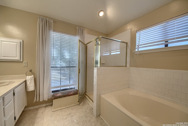 bathroom with independent shower and bath, vanity, and tile patterned flooring