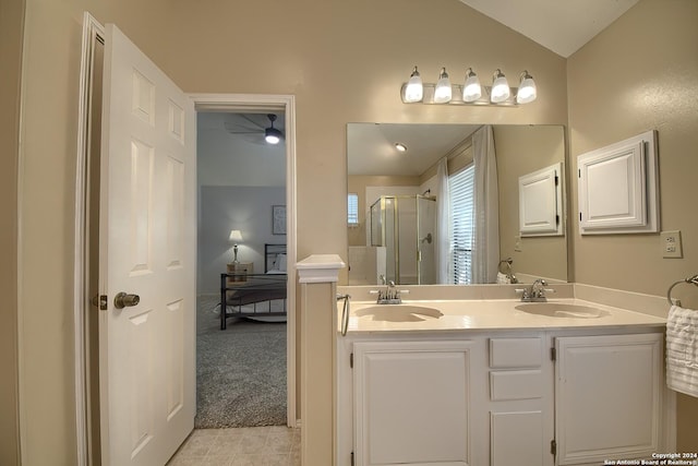ensuite bathroom featuring a shower stall, vaulted ceiling, a sink, and double vanity