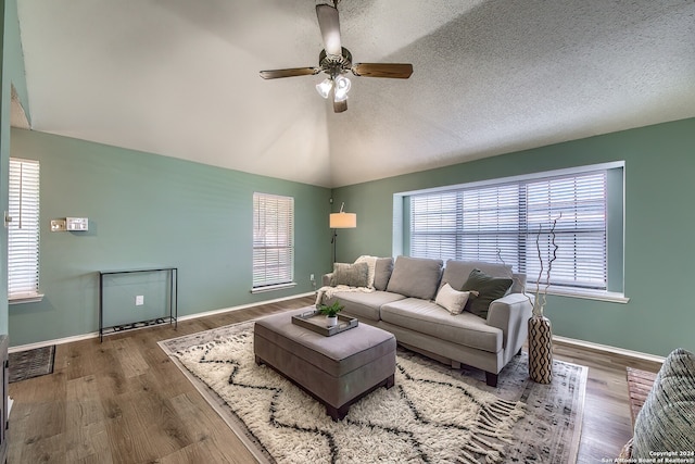 living room with a textured ceiling, lofted ceiling, hardwood / wood-style floors, and ceiling fan