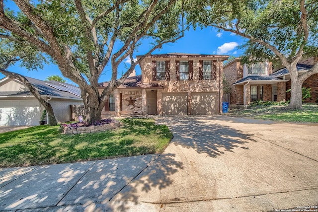 traditional-style home featuring brick siding, an attached garage, a front yard, and driveway