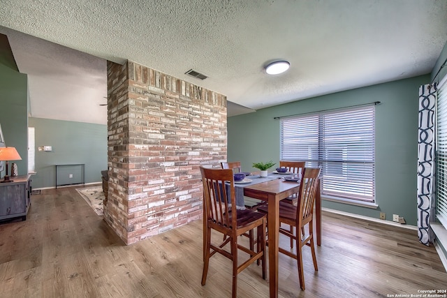 dining space with a textured ceiling and hardwood / wood-style flooring