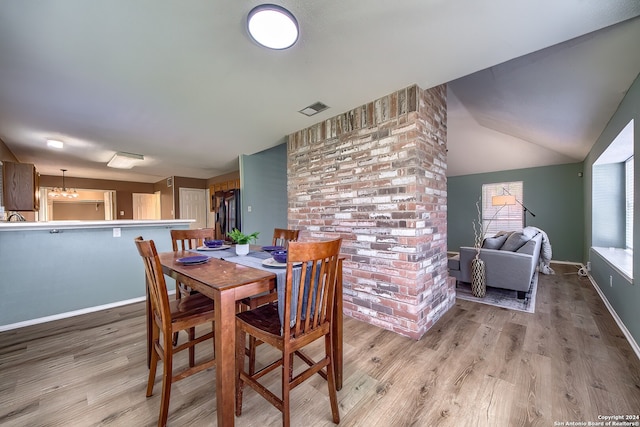 dining room featuring light hardwood / wood-style flooring and lofted ceiling