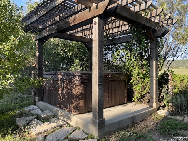 view of patio with a pergola and a hot tub